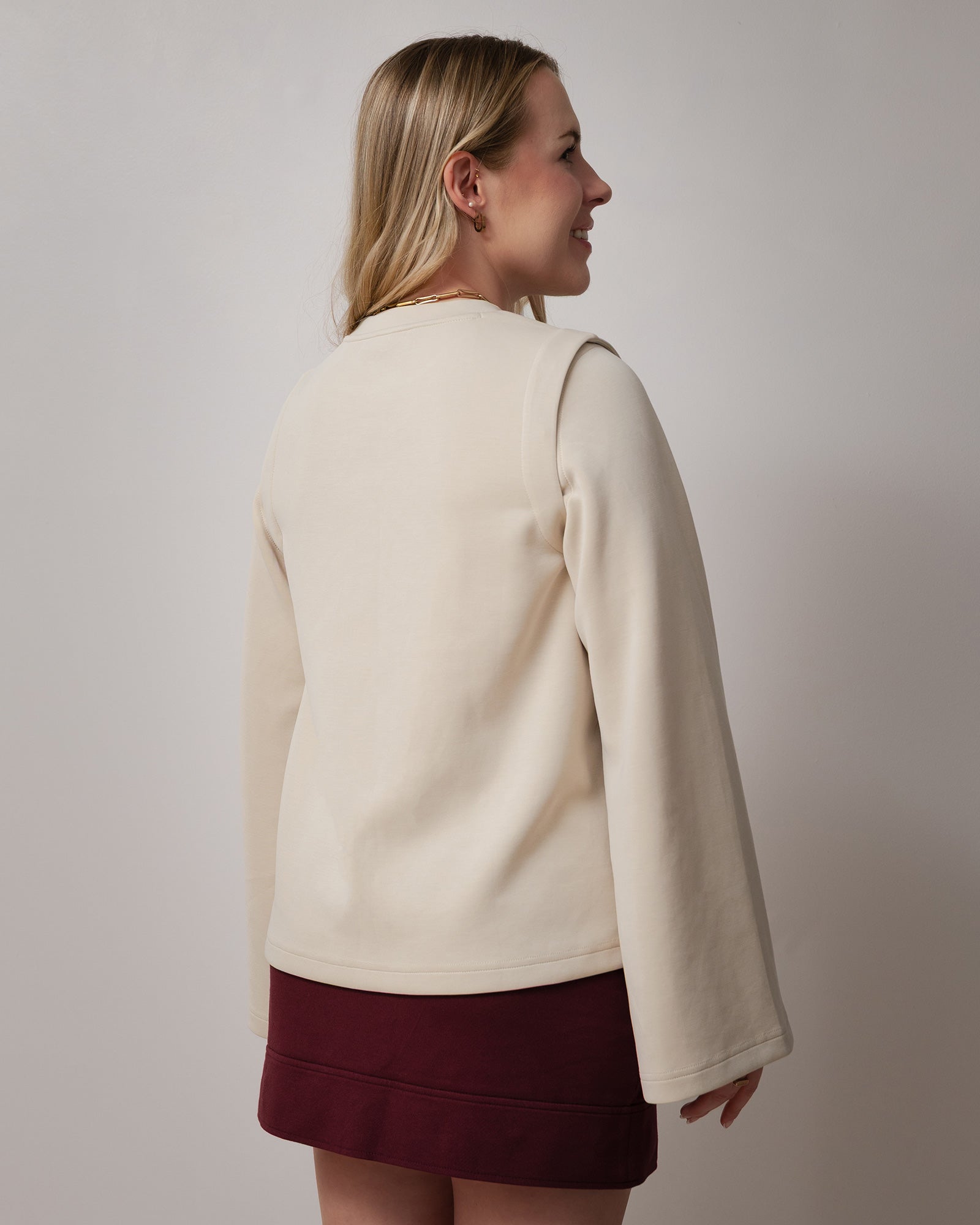 Chandail beige ample pour femme à manches longues amovibles et manches larges, avec col rond. Confectionné dans un tissu confortable et extensible, il offre une coupe décontractée et tendance, idéale pour un style moderne, polyvalent et facile à porter au quotidien.
